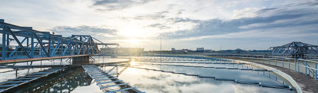 Foto van afvalwaterzuivering bij ondergaande zon